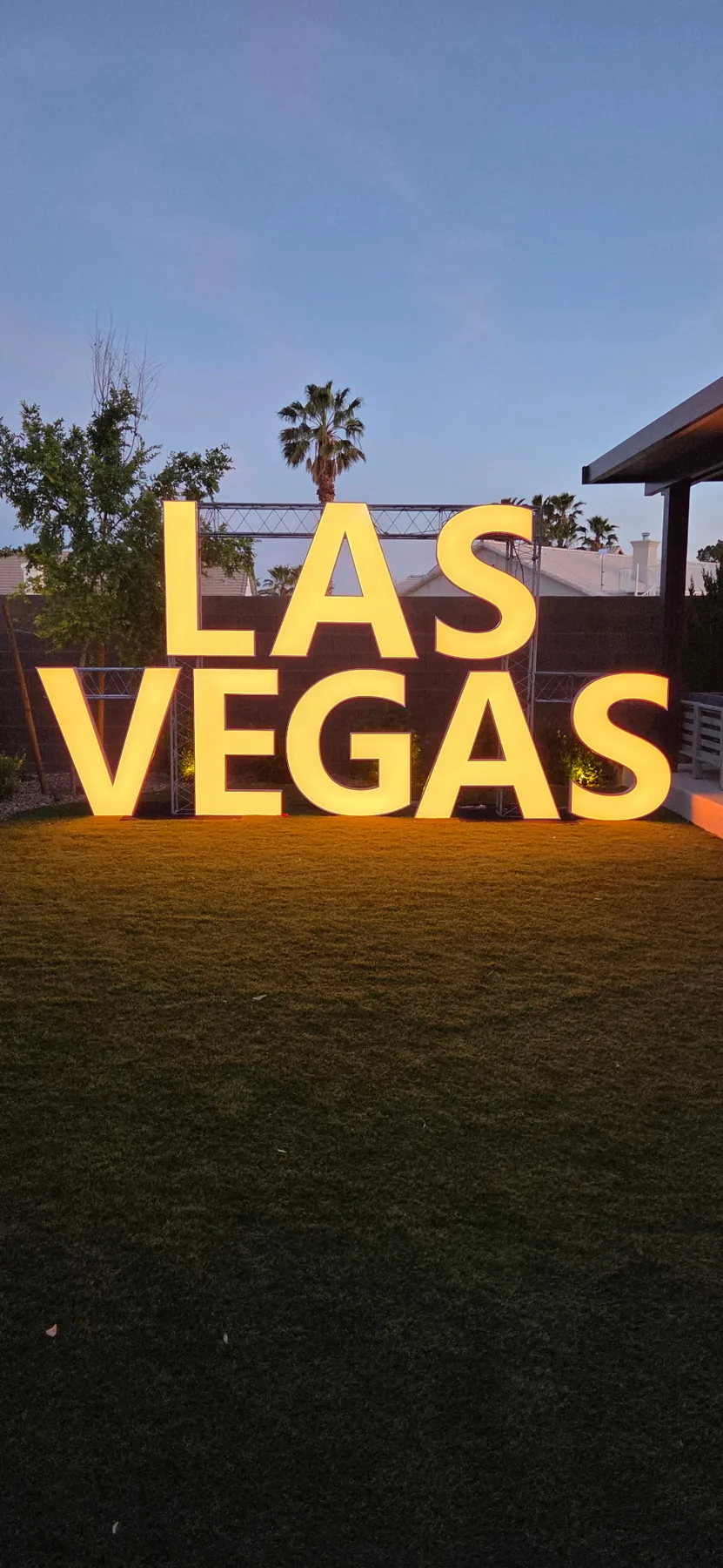 Stacked LAS VEGAS marquee letters glowing in warm amber
